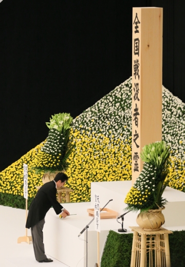 Shinzô Abe déposant une fleur lors d'une cérémonie en hommage aux morts lors de la Seconde Guerre Mondiale, 15 août 2015 (© Japan Kantei)