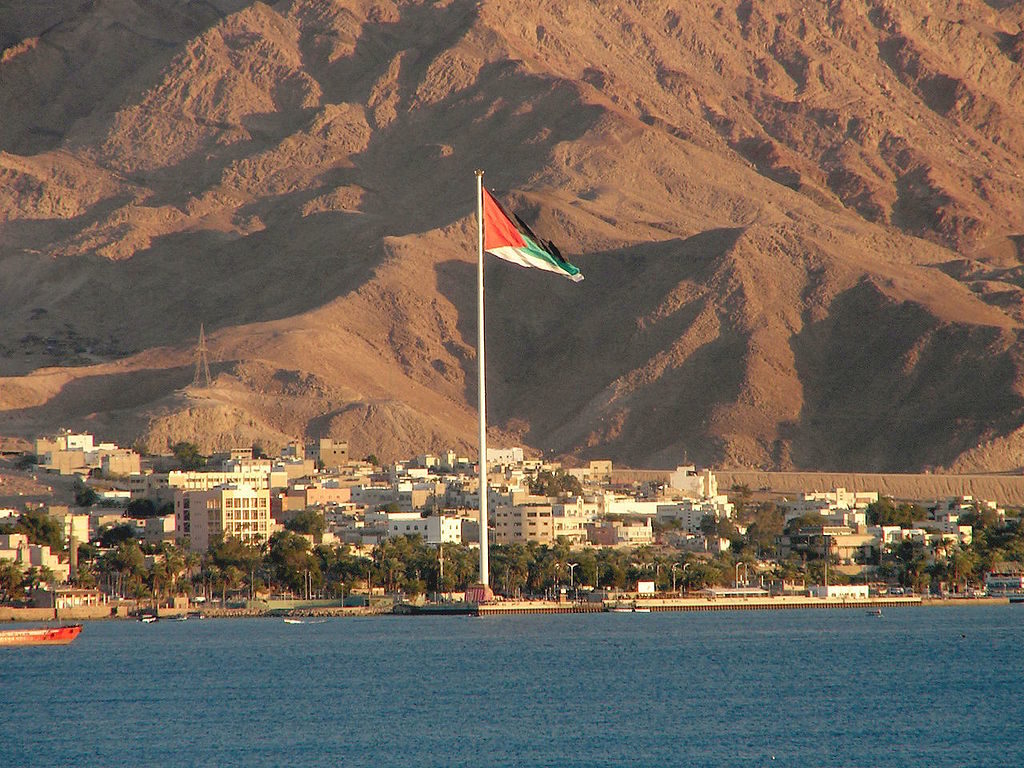 Le drapeau jordanien flottant sur la ville d'Aqaba (© Wikipedia)