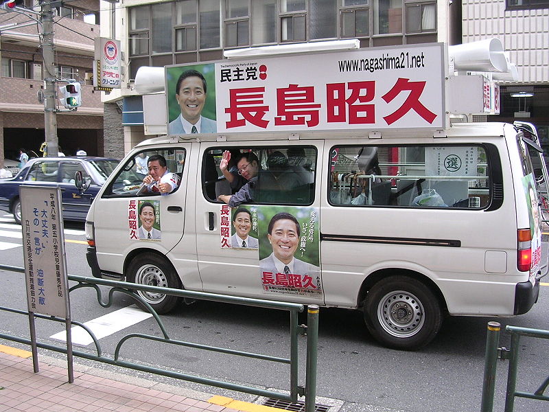 Le mini-bus de campagne d'un candidat du PDJ parcourant la ville en période d'élection (© Mkill)