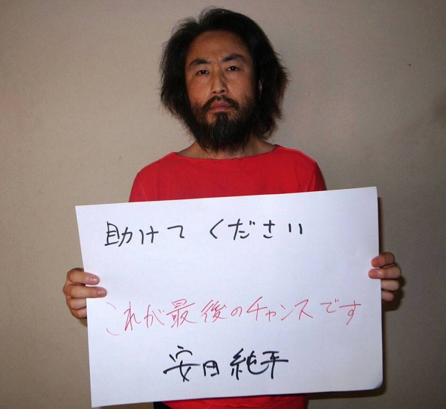 Photo de Jumpei Yasuda transmise par le groupe terroriste le détenant. on peut lire sur la pancarte : "Aidez-moi, ceci est ma dernière chance. Yasuda Jumpei"