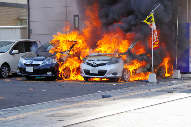 La voiture du suspect en flammes sur un parking (photo prsie par un résident)