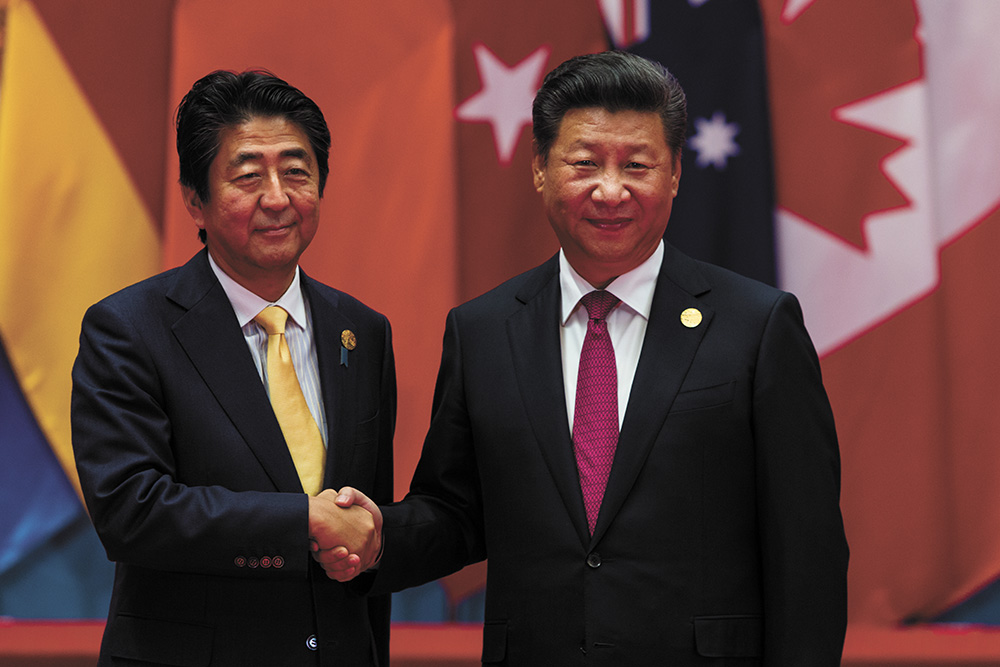 Le président de la Chine Xi Jinping serre la main du Premier ministre du Japon Sinzô Abe